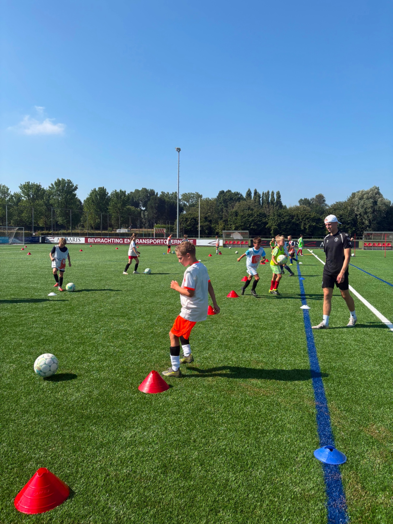 Jeugdspelers werken aan dribbeltechniek met pionnen