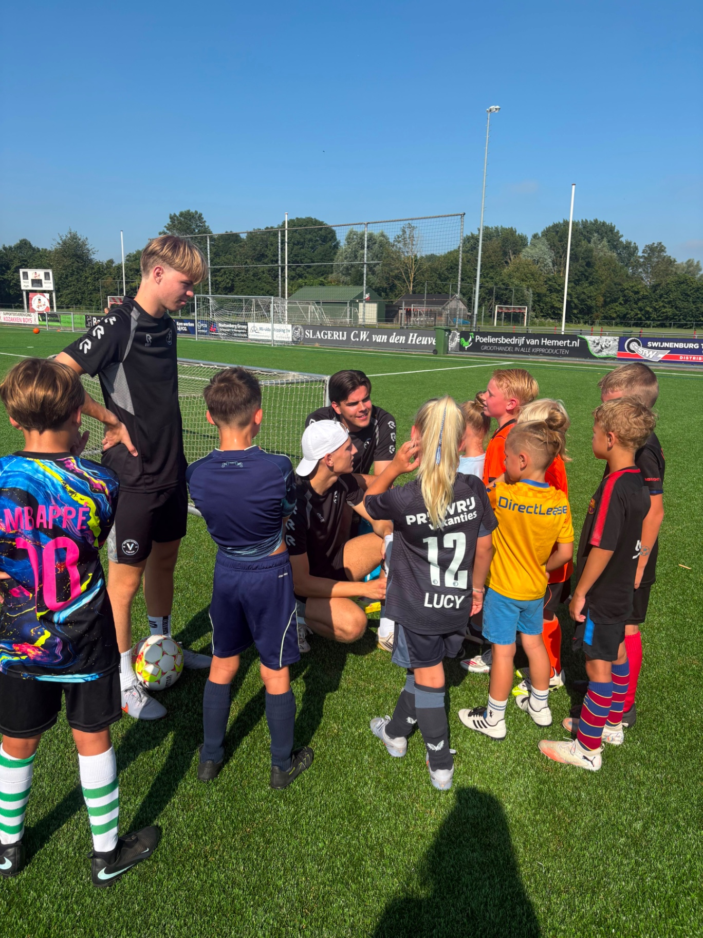 Coaches in kring met spelers tijdens uitleg